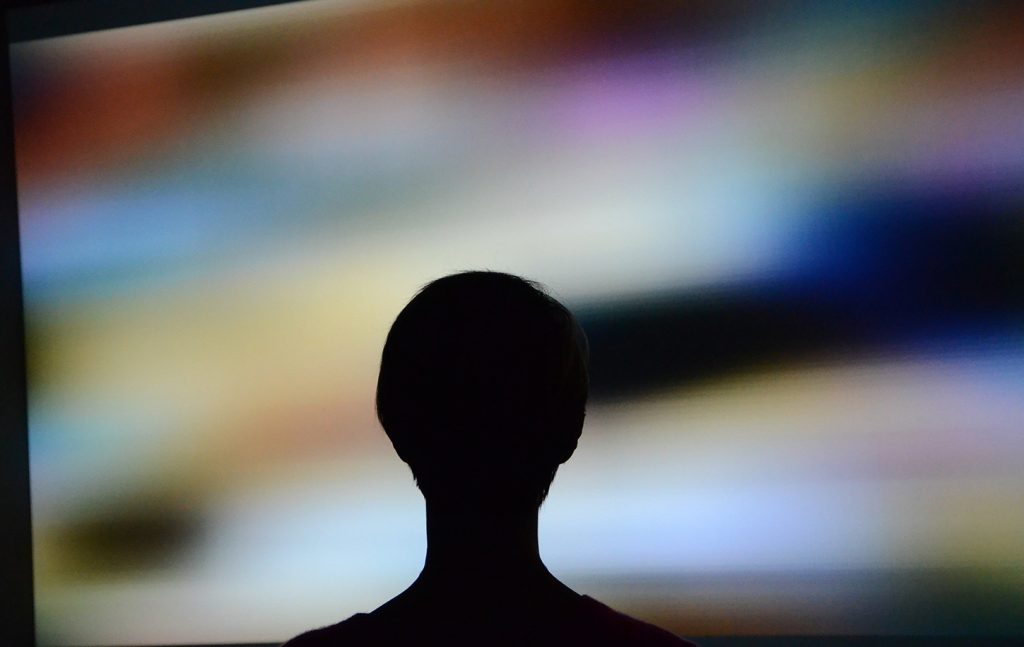 Silhouette of viewer in front of Signals and Stillness projected display.